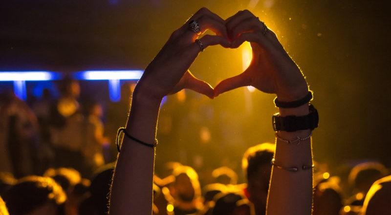 Hænder, der laver hjerteform, ved en koncert opdaget via eventbookinghjemmesider